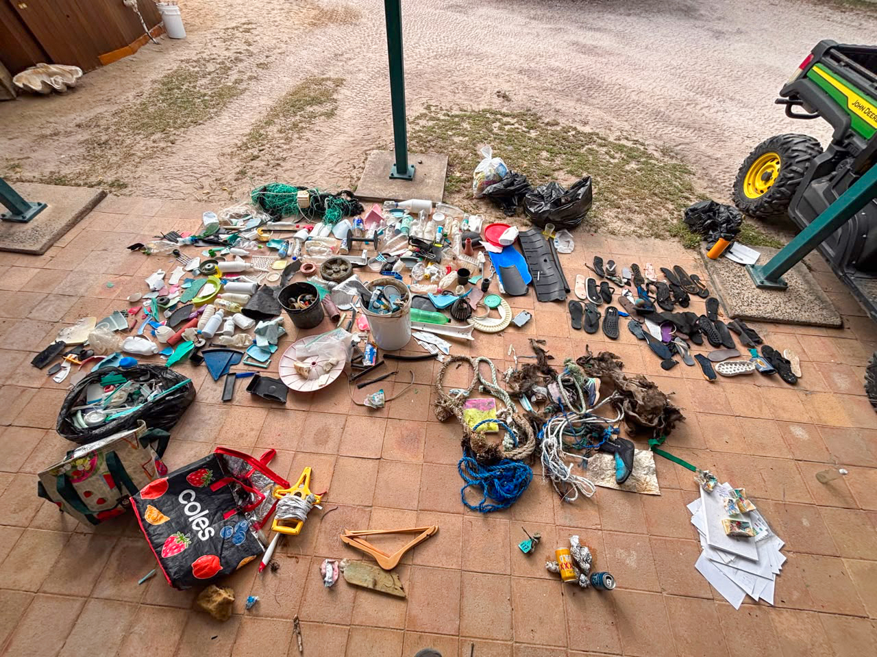 Authentic EDge, August 2026 issue — a day's haul of marine debris collected by a UC San Diego cohort on a beach near Cairns, Australia